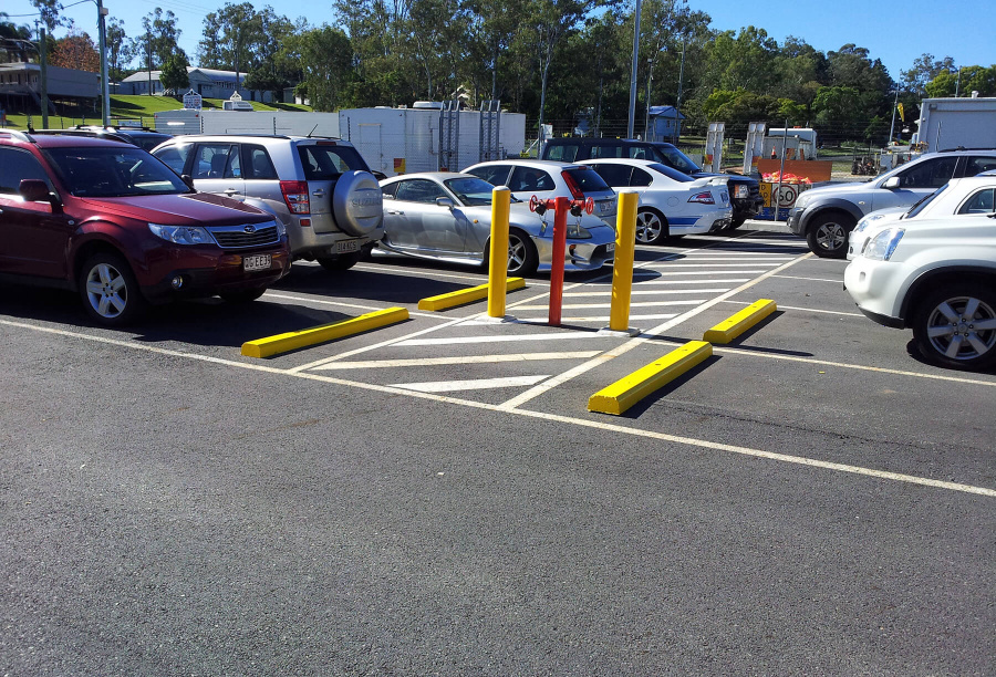 Car Park Wheel Stops Painted Yellow And Bollards Installed To Protect Fire Hydrant