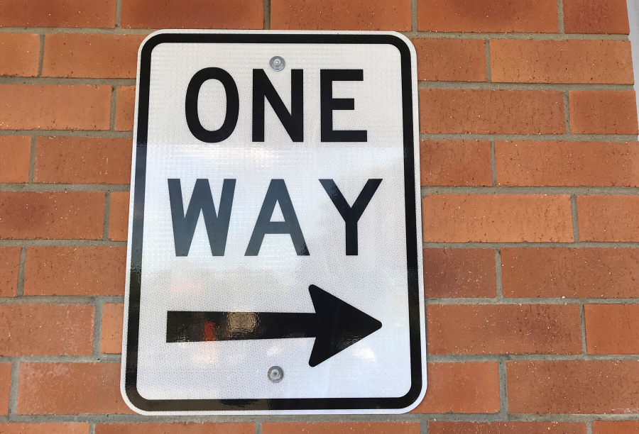 One Way Sign Fixed To Wall